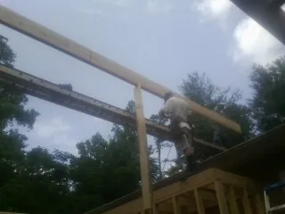 Carpenter setting a ridge beam over a new addition frame — Ice Dam Removal by Roofing Brothers in Centertown