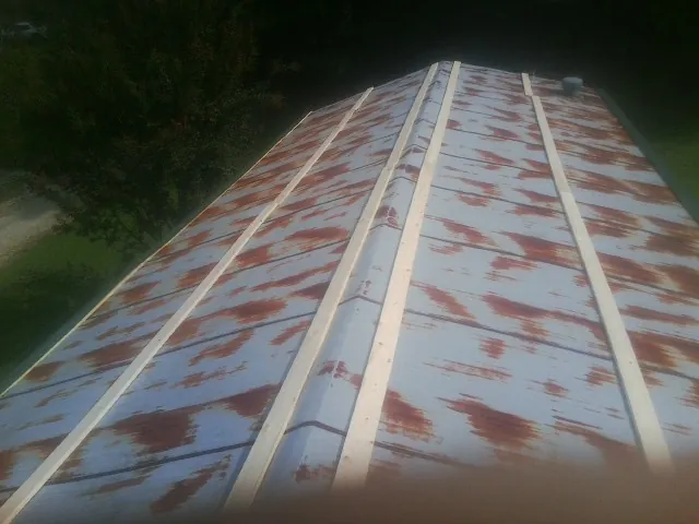 Rusted metal roof panels with new wood purlins before replacement — Storm Damage Roof Repair in Centertown by Roofing Brothers