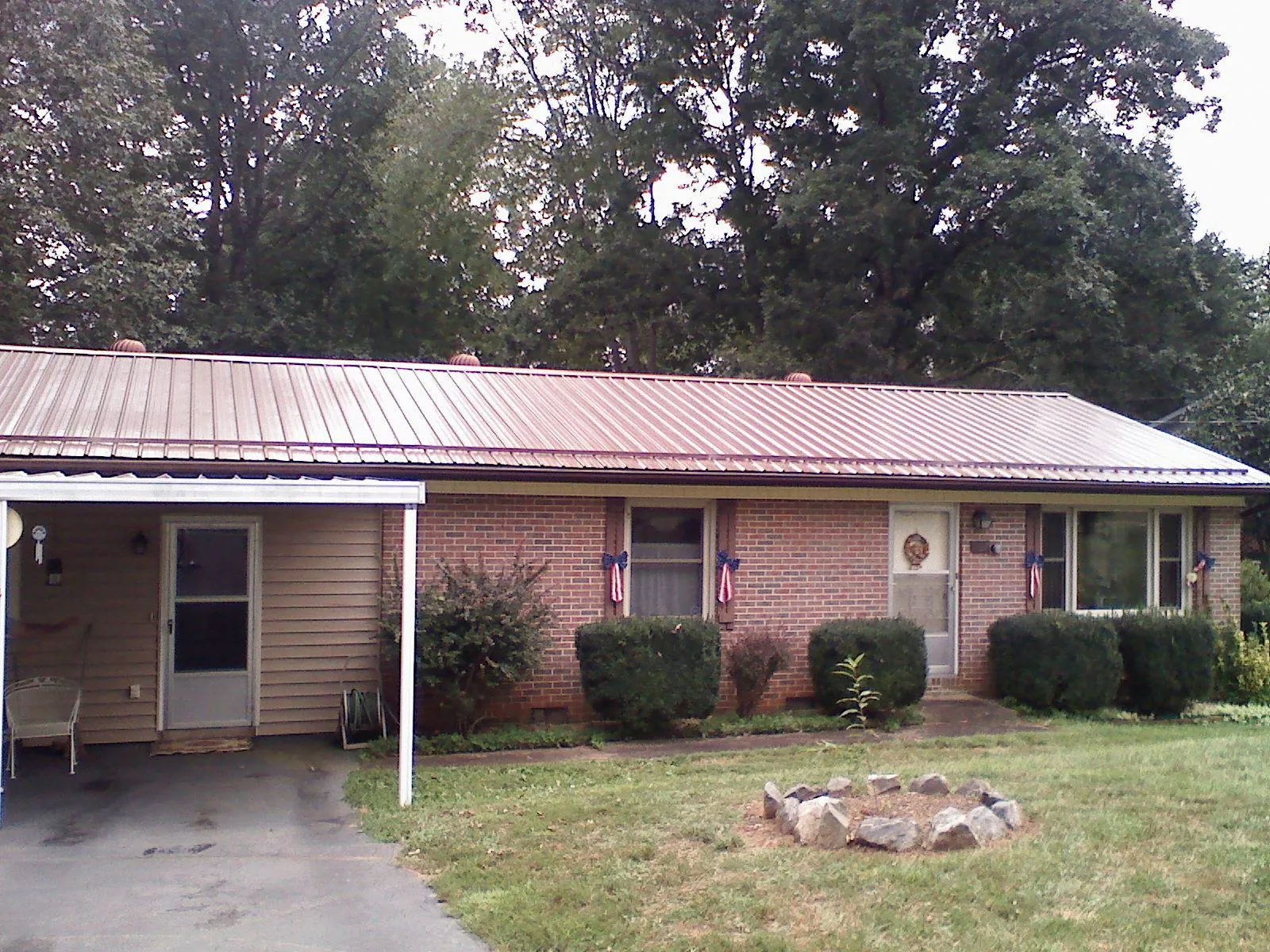 Bronze metal roof and carport on a brick ranch home — Roof Repair work by our crew in Centertown